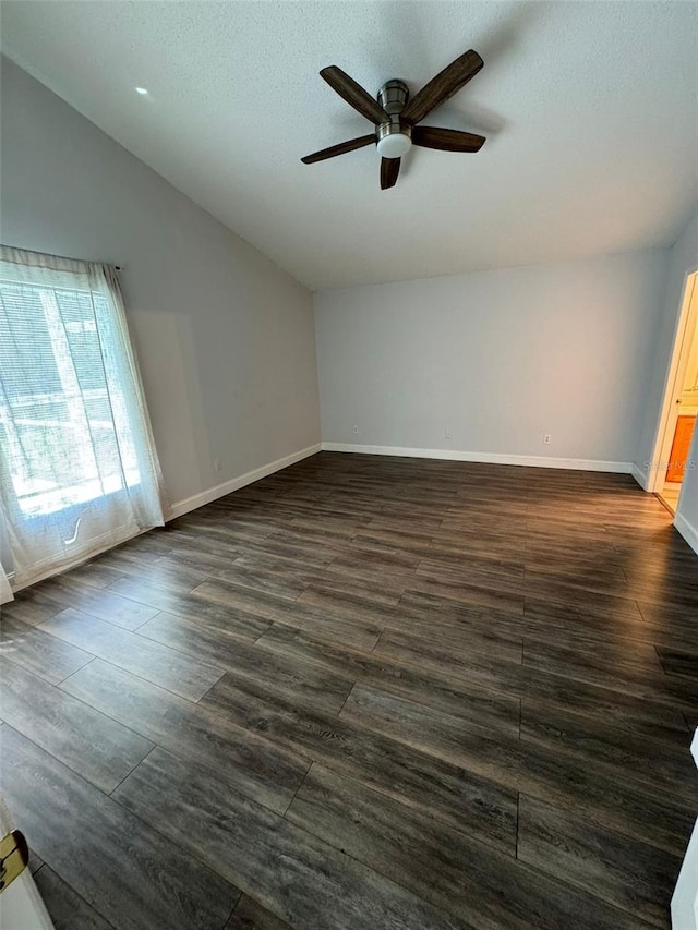 empty room featuring a textured ceiling, ceiling fan, dark hardwood / wood-style flooring, and vaulted ceiling