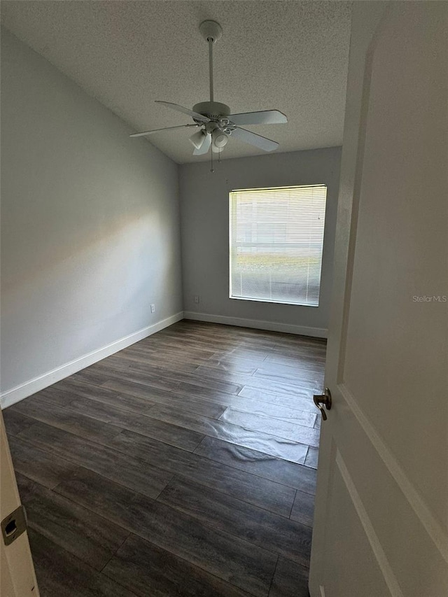 spare room with ceiling fan, dark wood-type flooring, and a textured ceiling