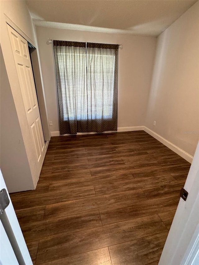 spare room featuring dark wood-type flooring