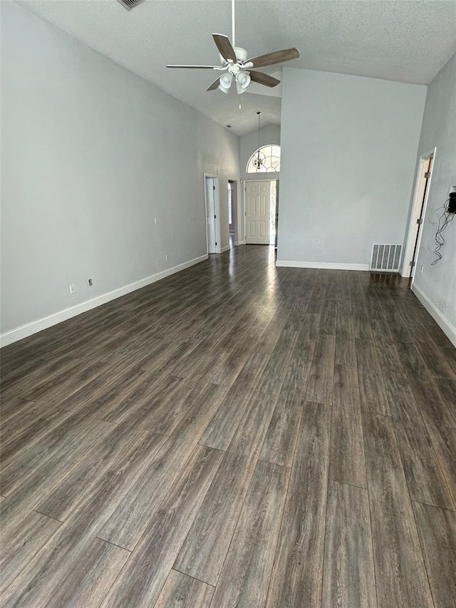 unfurnished living room featuring a textured ceiling, ceiling fan, dark wood-type flooring, and vaulted ceiling