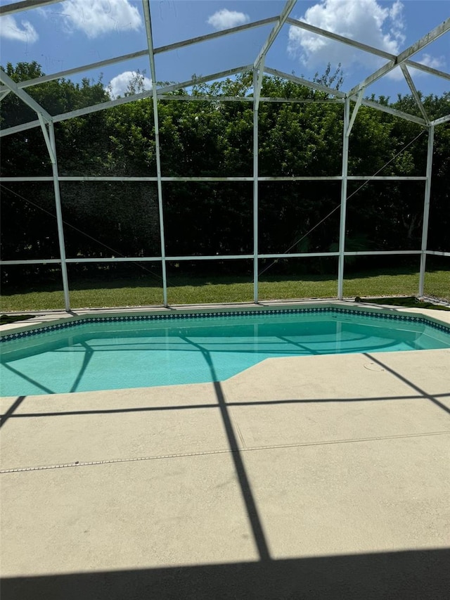 view of pool featuring glass enclosure and a patio