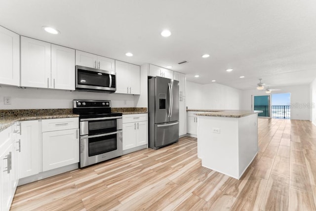 kitchen with white cabinets, ceiling fan, light hardwood / wood-style floors, and appliances with stainless steel finishes