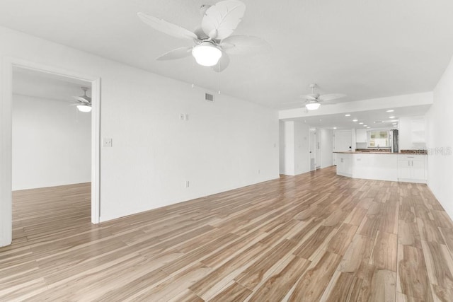 unfurnished living room with light hardwood / wood-style flooring and ceiling fan