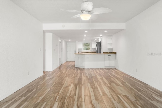 unfurnished living room with light hardwood / wood-style floors and ceiling fan