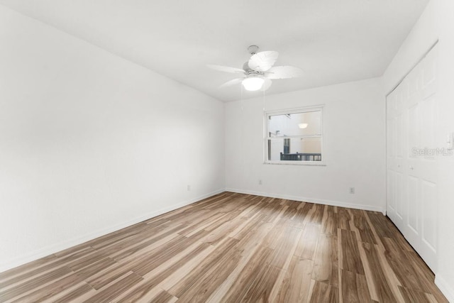 spare room featuring wood-type flooring and ceiling fan