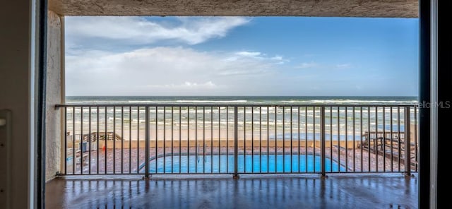 balcony featuring a water view and a beach view