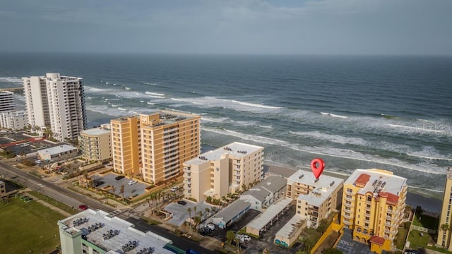 birds eye view of property with a water view and a beach view