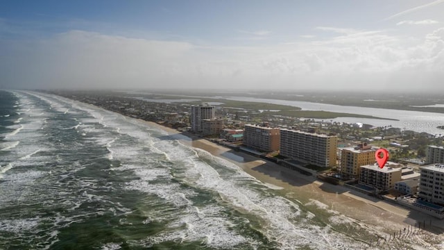 birds eye view of property with a water view and a beach view