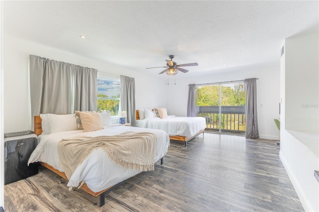 bedroom featuring ceiling fan, dark hardwood / wood-style floors, access to exterior, and multiple windows