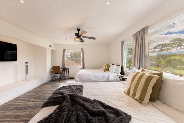 bedroom with ceiling fan, wood-type flooring, and a textured ceiling