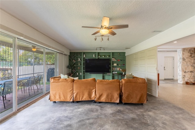 living room featuring a textured ceiling and ceiling fan