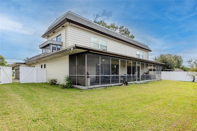 back of property featuring a sunroom and a yard