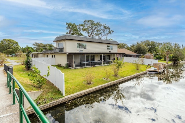 back of house featuring a sunroom and a water view