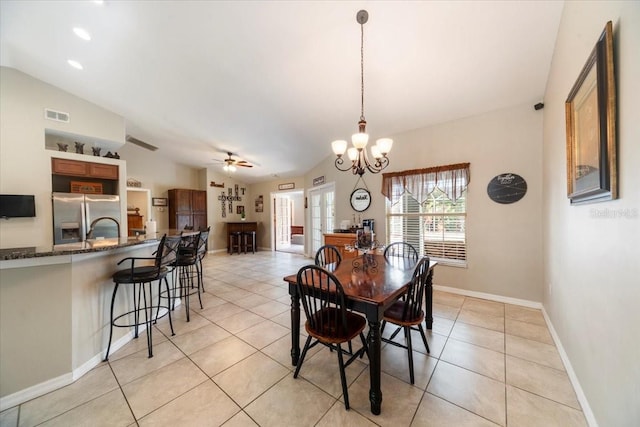 tiled dining room featuring ceiling fan with notable chandelier and lofted ceiling