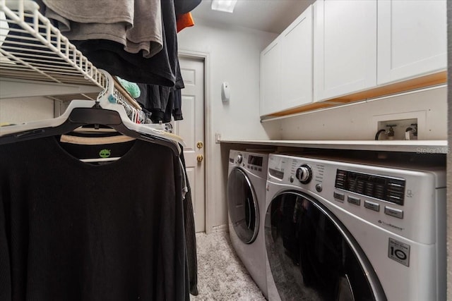 laundry area with washer and clothes dryer, cabinets, and light carpet