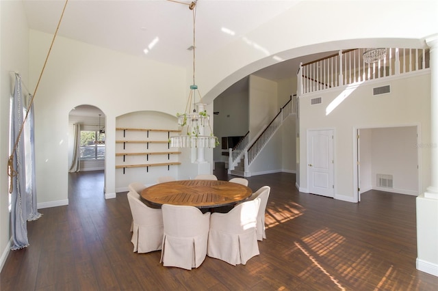 unfurnished dining area featuring dark wood-type flooring and a high ceiling