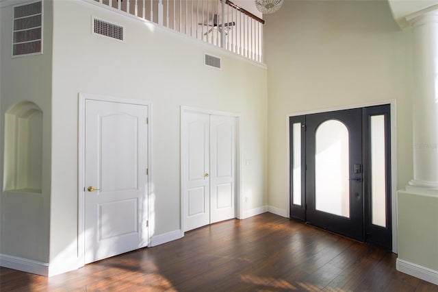 entryway with dark hardwood / wood-style flooring, a high ceiling, and ornate columns