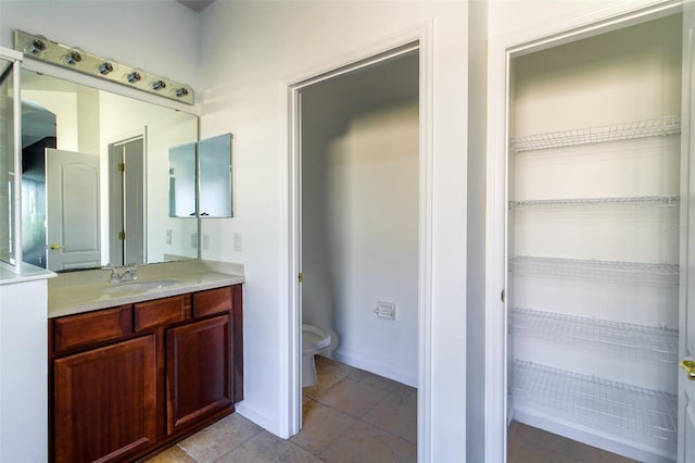 bathroom featuring vanity, tile patterned floors, and toilet