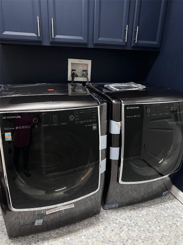 washroom with cabinets and washer and clothes dryer