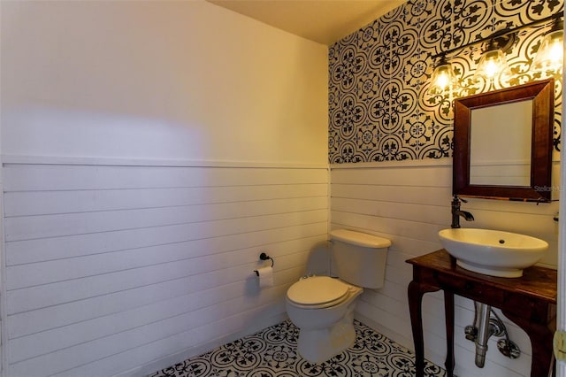 bathroom with toilet, tile patterned flooring, and sink