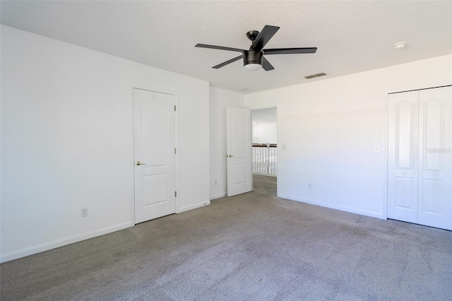 unfurnished bedroom featuring ceiling fan, carpet flooring, and a textured ceiling