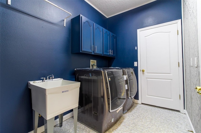 laundry area with cabinets, sink, washing machine and clothes dryer, and a textured ceiling