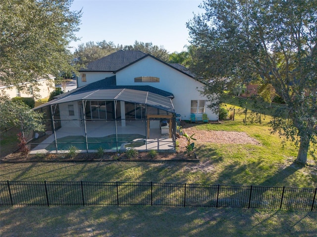 rear view of property featuring a fenced in pool, a lawn, glass enclosure, and a patio area