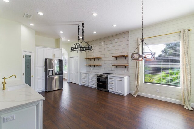 kitchen featuring pendant lighting, appliances with stainless steel finishes, white cabinetry, light stone countertops, and dark hardwood / wood-style flooring