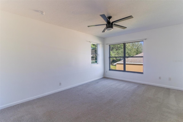 carpeted empty room with ceiling fan and a textured ceiling