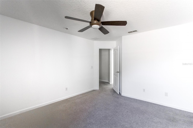 spare room featuring ceiling fan, carpet, and a textured ceiling