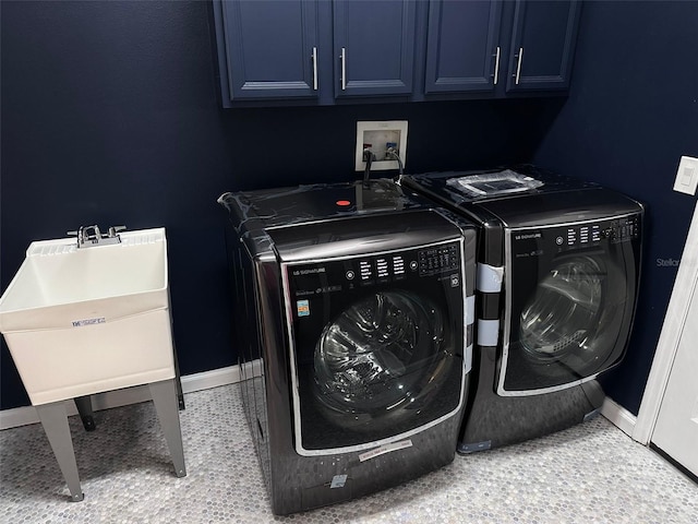 laundry room with sink, washer and clothes dryer, and cabinets