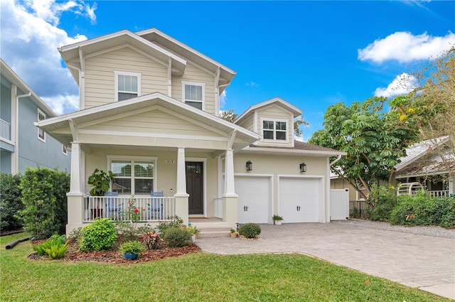 view of front of property with a front lawn, covered porch, and a garage