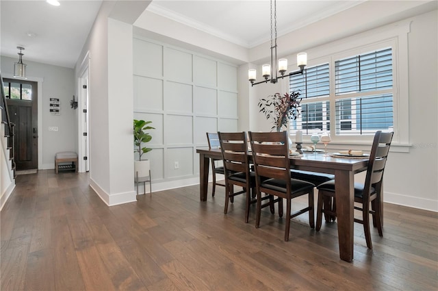 dining space featuring dark hardwood / wood-style flooring, crown molding, and a chandelier