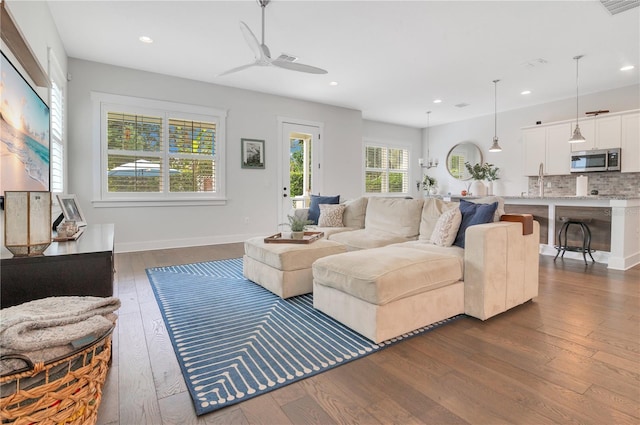 living room with ceiling fan and dark hardwood / wood-style flooring