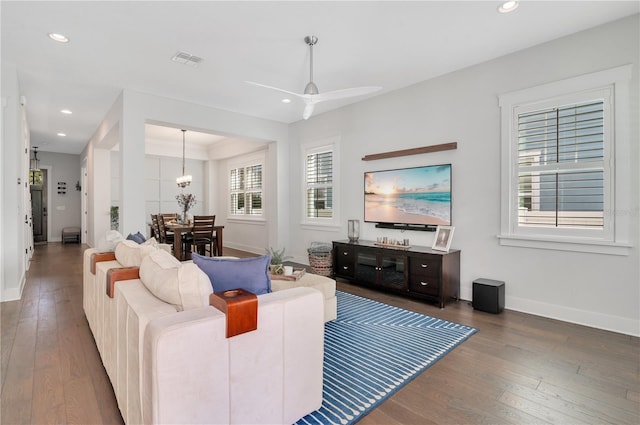 living room featuring dark hardwood / wood-style floors and ceiling fan with notable chandelier