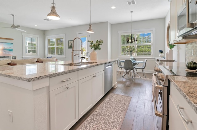 kitchen featuring white cabinetry, sink, stainless steel appliances, an island with sink, and pendant lighting