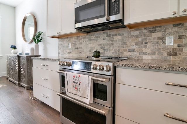 kitchen featuring dark wood-type flooring, appliances with stainless steel finishes, tasteful backsplash, light stone counters, and white cabinetry