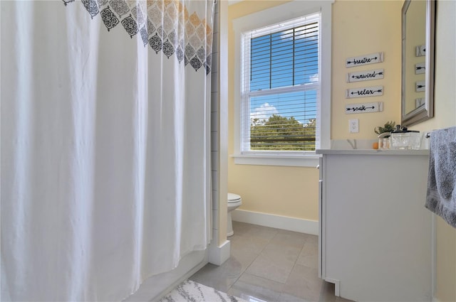 full bathroom with shower / bath combo with shower curtain, tile patterned flooring, vanity, and toilet