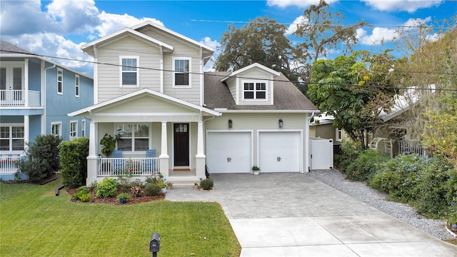 view of front of house with covered porch, a front yard, and a garage