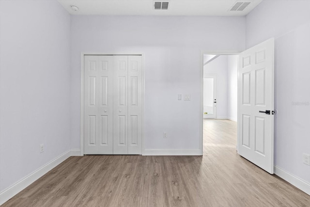 unfurnished bedroom featuring light hardwood / wood-style floors and a closet