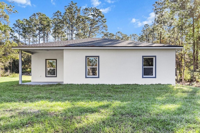 view of side of home with a lawn and a patio area