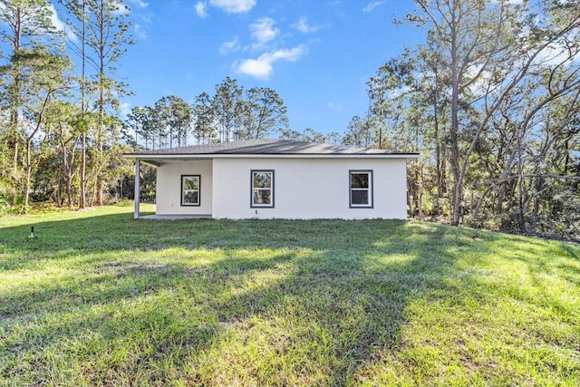 rear view of property with a yard