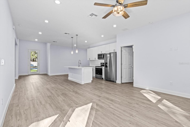 unfurnished living room with ceiling fan, sink, and light wood-type flooring