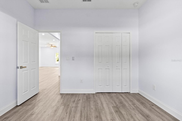 unfurnished bedroom with light hardwood / wood-style floors and a closet