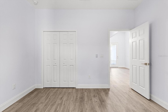 unfurnished bedroom featuring a closet and light hardwood / wood-style flooring