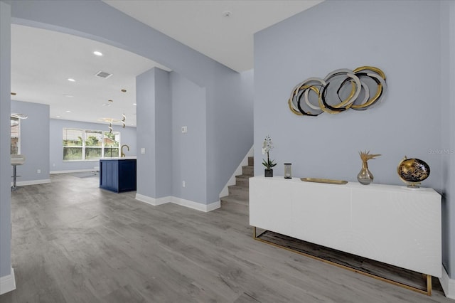 living room featuring sink and light hardwood / wood-style flooring