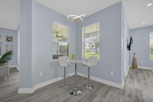 dining space with light hardwood / wood-style floors and a notable chandelier