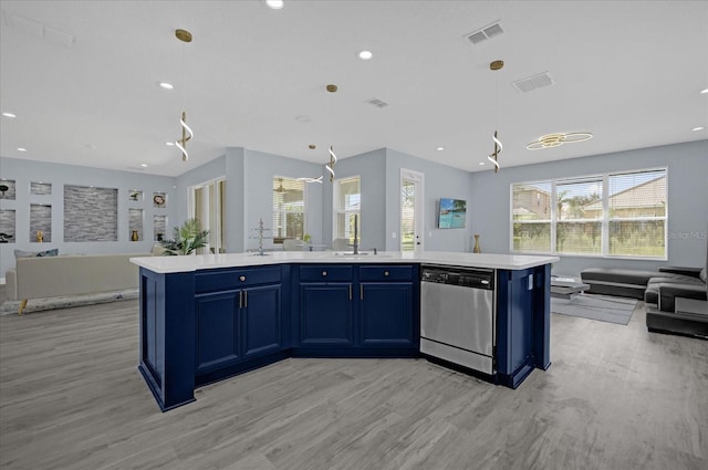 kitchen featuring a center island with sink, dishwasher, blue cabinetry, and light hardwood / wood-style flooring