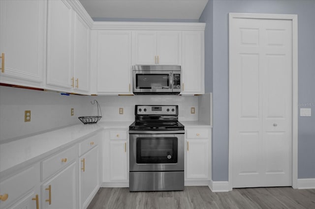 kitchen with white cabinetry, appliances with stainless steel finishes, and light hardwood / wood-style flooring