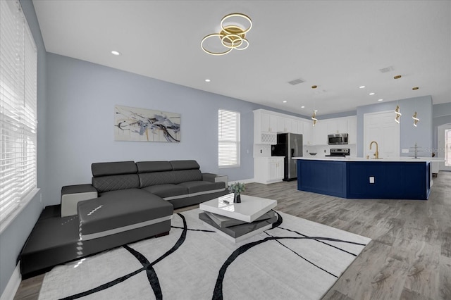 living room with light wood-type flooring and sink